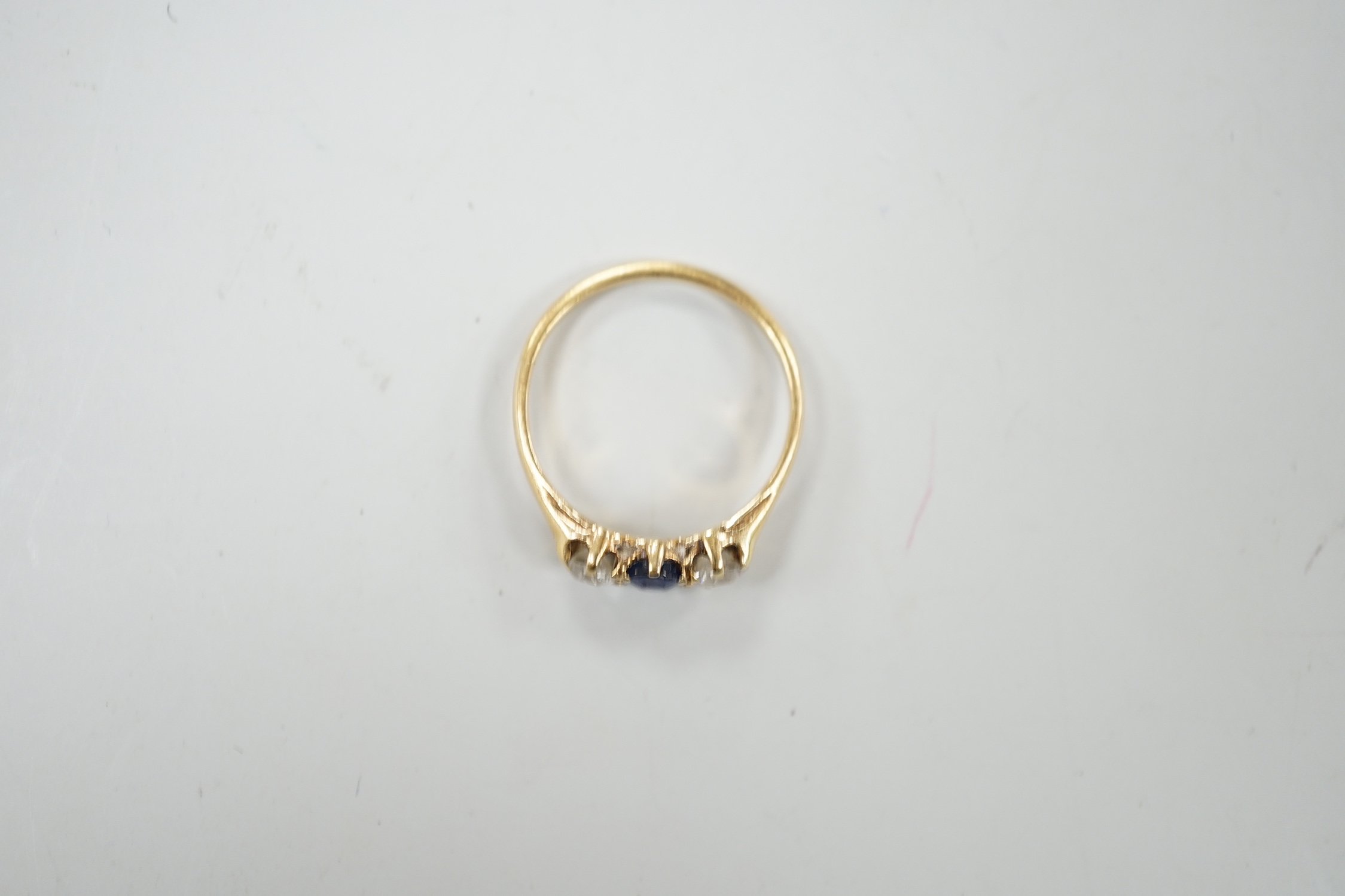 A yellow metal, single stone sapphire and two stone diamond set ring, size L, gross weight 2.3 grams.